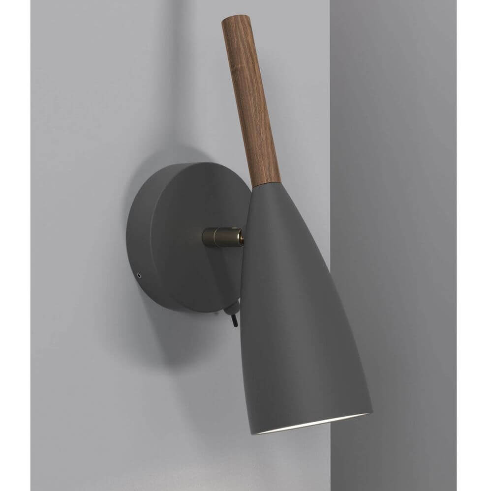 Pure Wandleuchte Silber, Grau mit geöltem Nussbaumgriff an grauem Wand.