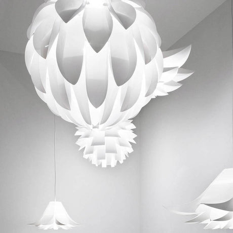 Zaokrąglona lampa wisząca Norm12 XL Biała w nowoczesnym pomieszczeniu z łagodnym światłem.