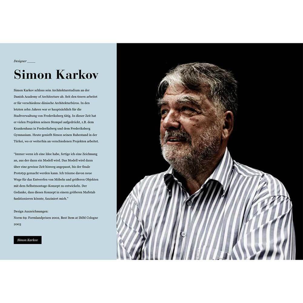 Portrait von Simon Karkov, Designer und Architekt, mit kurzem grauem Bart und gestreiftem Hemd.