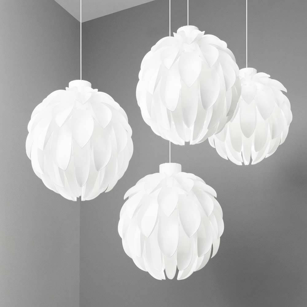 Abgerundete Pendelleuchte Norm12 XL Weiß in einem modernen Interieur, vier runde weiße Leuchten mit sanftem Licht.