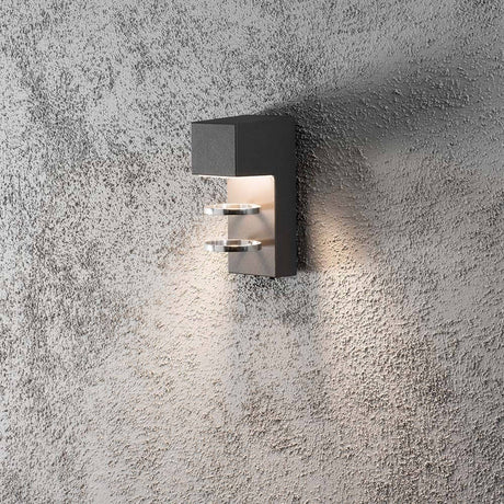 Acerra LED anthracite outdoor wall light installed on a rough wall, with soft lighting.
