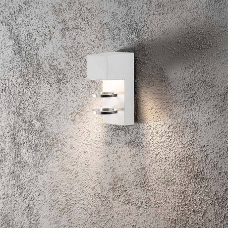 Acerra LED Außen-Wandleuchte Weiß an einer strukturierten Wand montiert, beleuchtet den Raum.