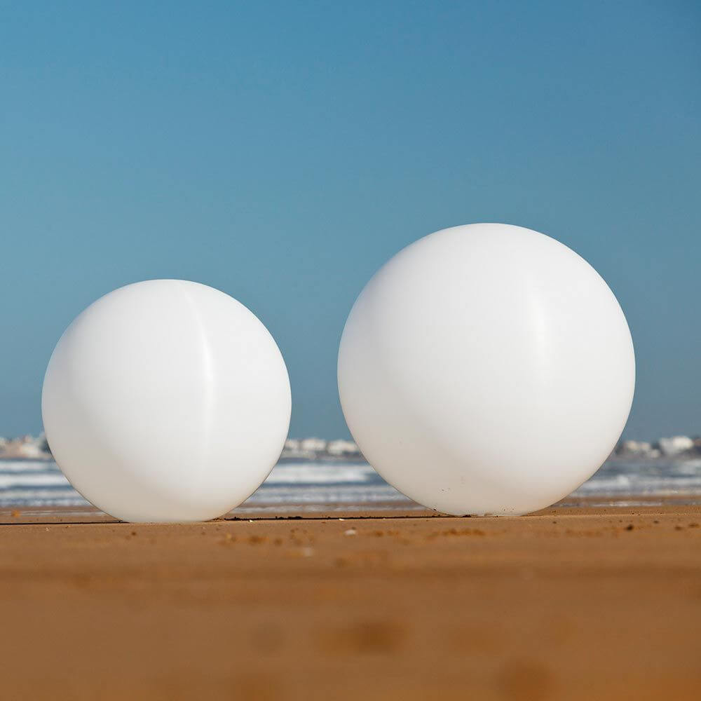 Akku LED-Lichtkugel Ball in zwei Größen am Strand, ideal für entspannte Momente und moderne Außenbereiche.