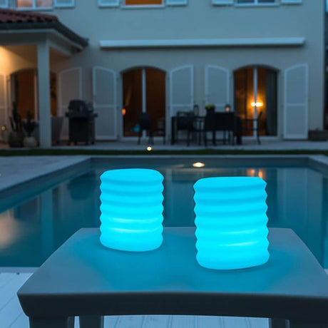 Lampada di design a lanterna sospendibile a batteria LED con controllo tramite app in luce calda a bordo piscina al crepuscolo.