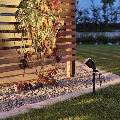 Amalfi LED borne sur piquet 1 lampe 12 V noire à côté d’un habillage mural en bois moderne dans le jardin.
