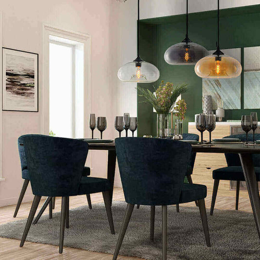 Eleganter Essbereich mit stilvollen blauen Stühlen, einem modernen Tisch und einzigartigen Pendelleuchten.