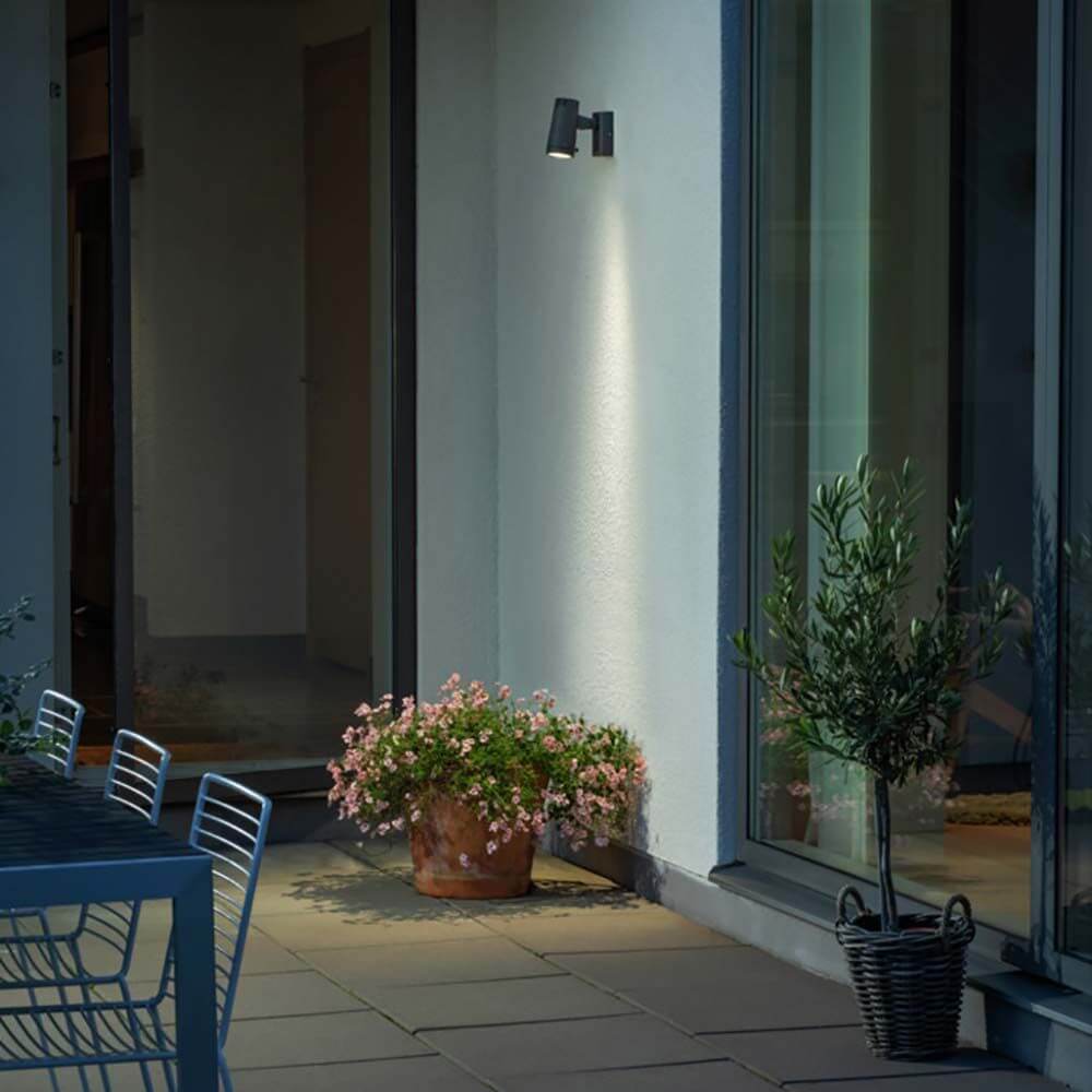 Andria LED Außen Strahler Anthrazit beleuchtet Eingangsbereich mit blühendem Topf und Pflanzen.
