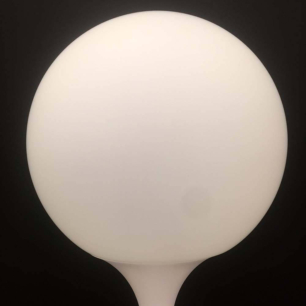 Artemide Castore Tischleuchte mit runder, opalweißer Glasoberfläche, ideal für stimmungsvolle Wohnzimmerbeleuchtung.