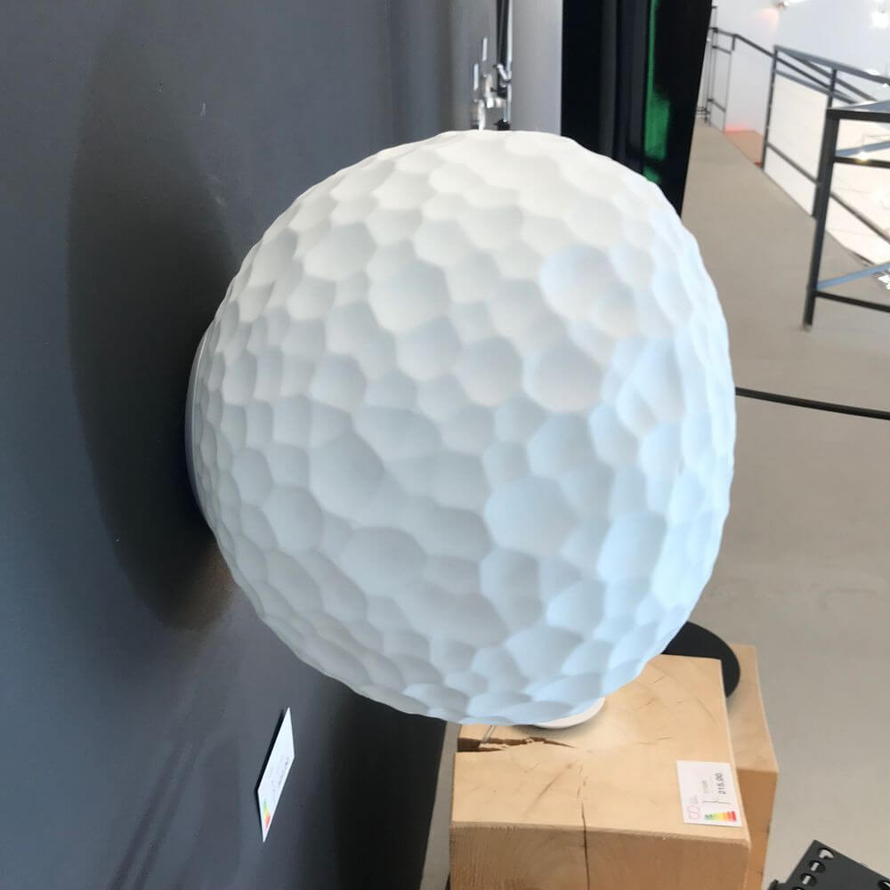 Kreative Wandlampe in kugelrunder Form aus weißem, strukturiertem Material für modernes Interior-Design.