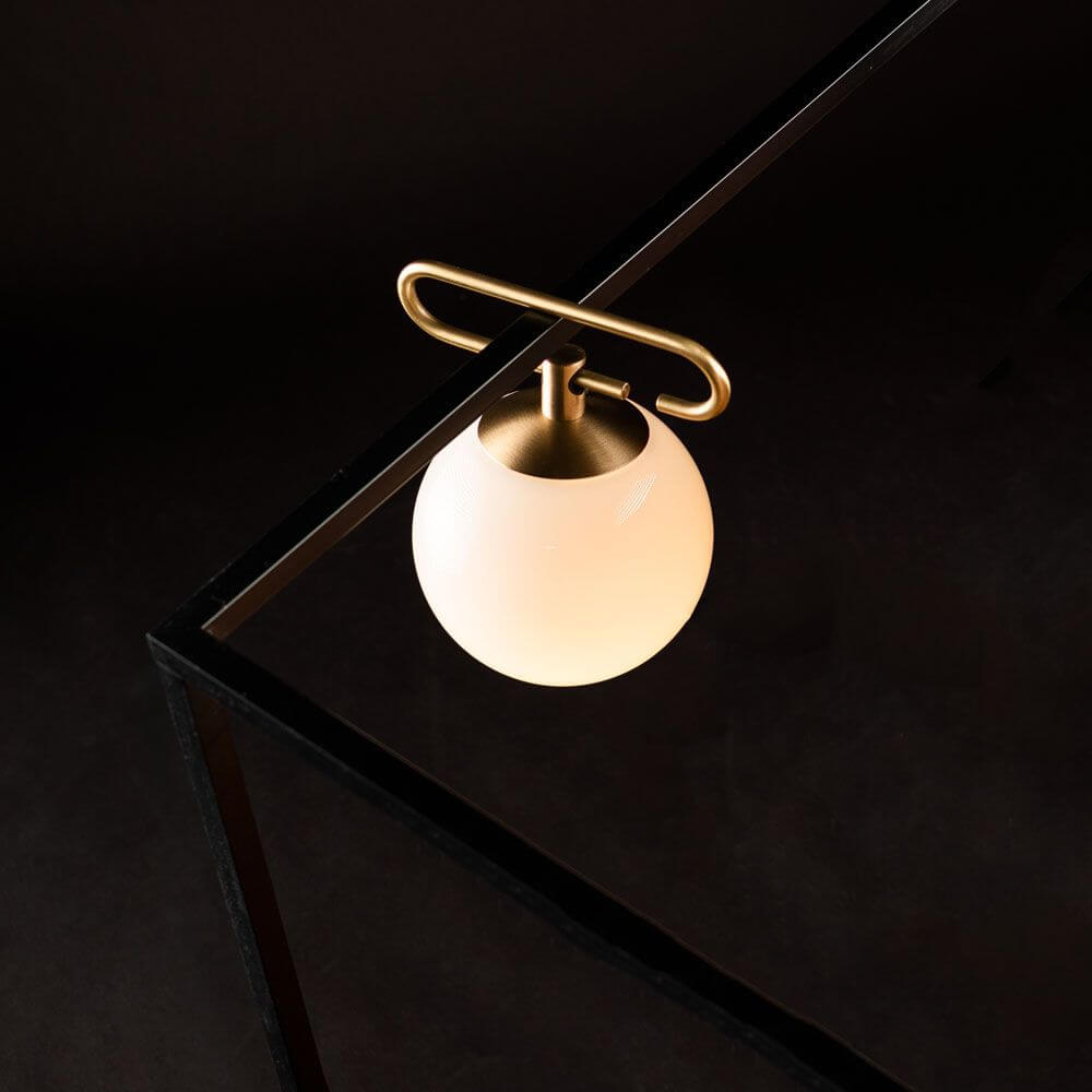 Artemide NH 1217 Tischlampe mit edlem Messingring und eleganter Glasleuchte, vielseitig als Tisch-, Pendel- oder Wandleuchte.