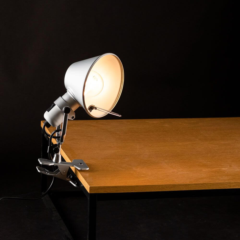 Artemide Tolomeo Pinza Klemmleuchte drehbar auf einem Tisch, ideal für kleine Räume.