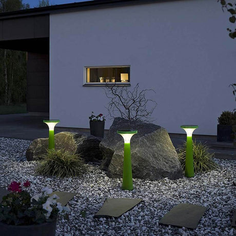 Solar LED Terrassenleuchte Assisi Aton Grün beleuchtet einen Gartenbereich bei Nacht.