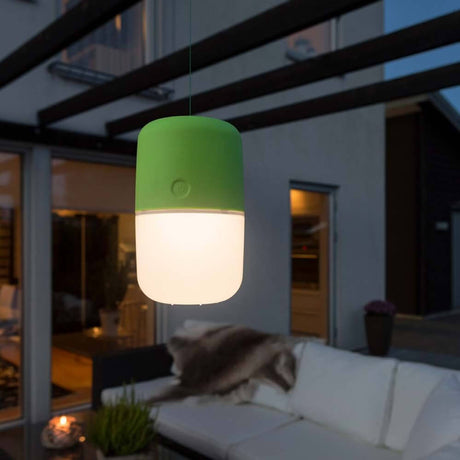 Assisi Solar LED lamp for hanging or standing Green outdoors at night, ideal for garden lighting.