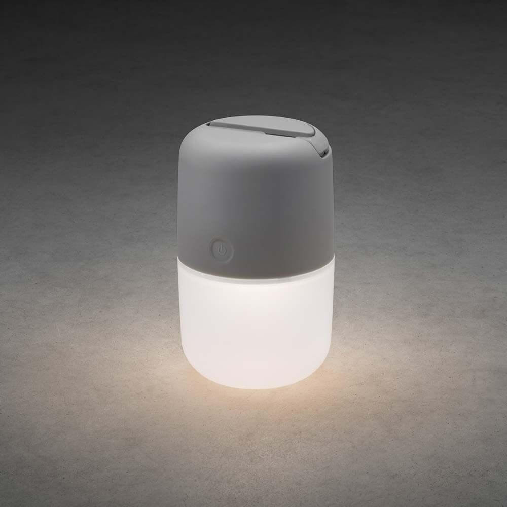 LED solar light Assisi for hanging or standing gray on a dark background, shining brightly.