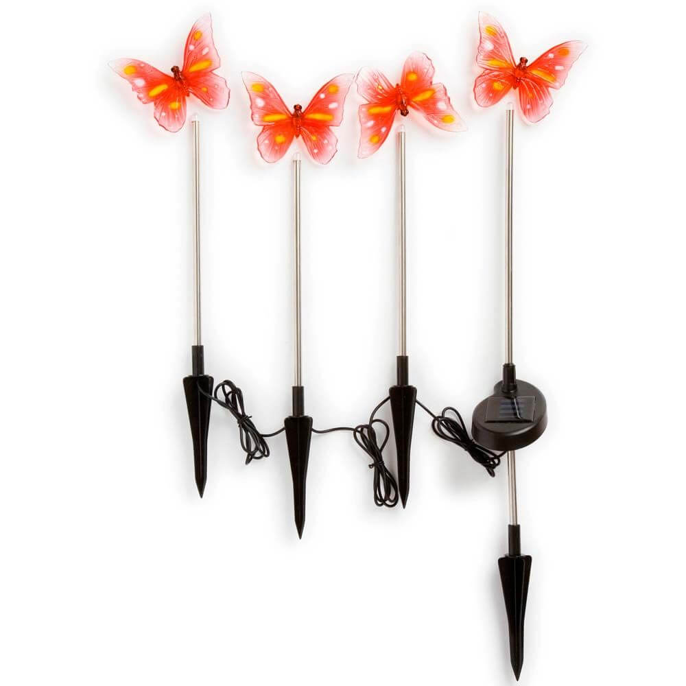 Assisi Solar LED Schmetterling Set 4-tlg. mit vier bunten Schmetterlingen auf Solarstäben in einem Garten.