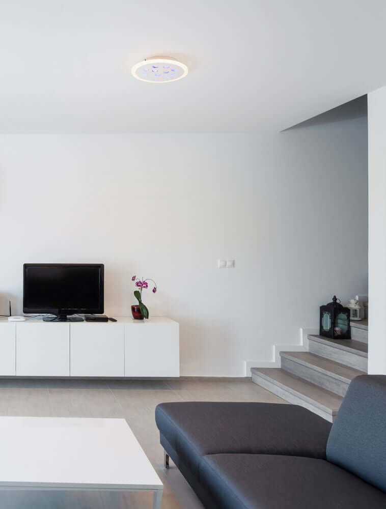Astro LED Deckenleuchte 3000K Weiß in modernem Wohnraum über einer Couch und Fernseher.
