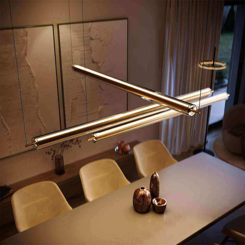 Moderne Hängeleuchte über einem eleganten Esstisch mit stilvollen Stühlen und dekorativen Vasen im Hintergrund.