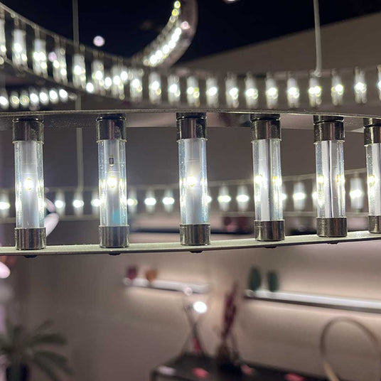 Helle LED-Beleuchtung in einer modernen Leuchte mit transparenten Röhren und elegantem Design.