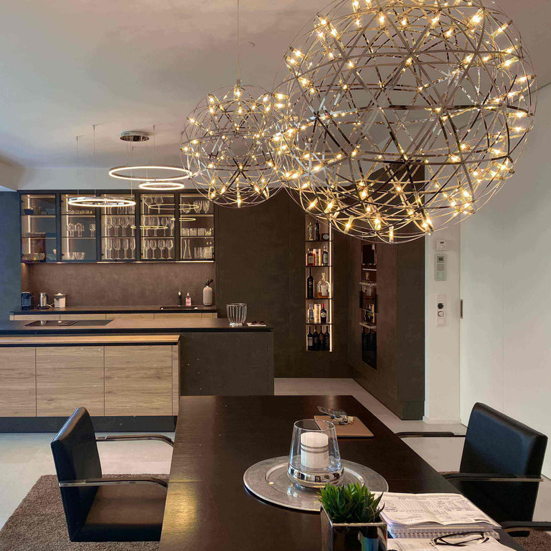 Moderne Küche mit stilvollen Pendelleuchten und Holzregalen im Hintergrund.