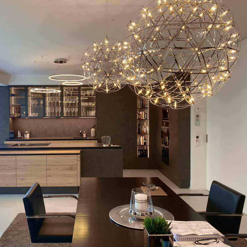 Moderne Küche mit stilvollen Pendelleuchten und Holzregalen im Hintergrund.