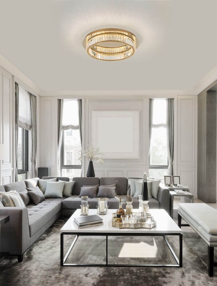 Moderne Wohnzimmereinrichtung mit Aurelia LED Deckenleuchte in Gold und stilvollem Sofa.