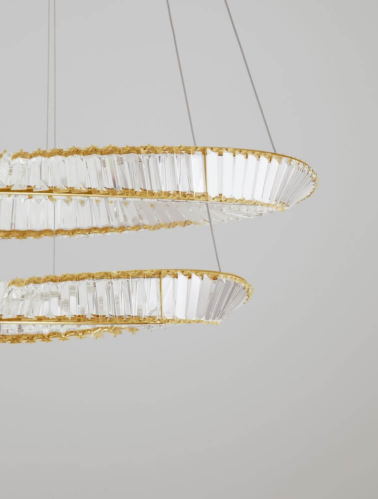 Aurelia LED Pendelleuchte 3500K Gold mit geometrischen Ringen und facettierten Glasstäben.
