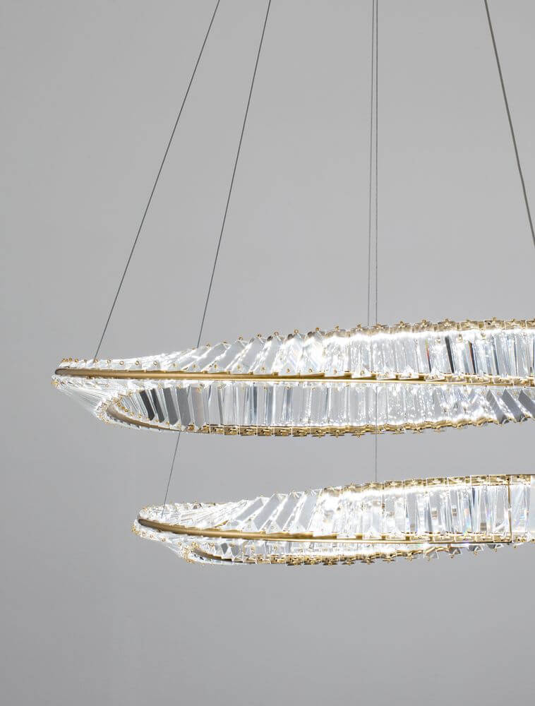 Aurelia LED Pendelleuchte 3500K Gold mit goldenen Ringen und facettierten Glasstäben.