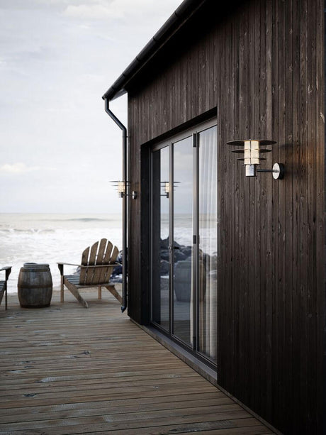 Außenwandlampe Bastia 35 IP54 an einer Holzfassade mit Meerblick
