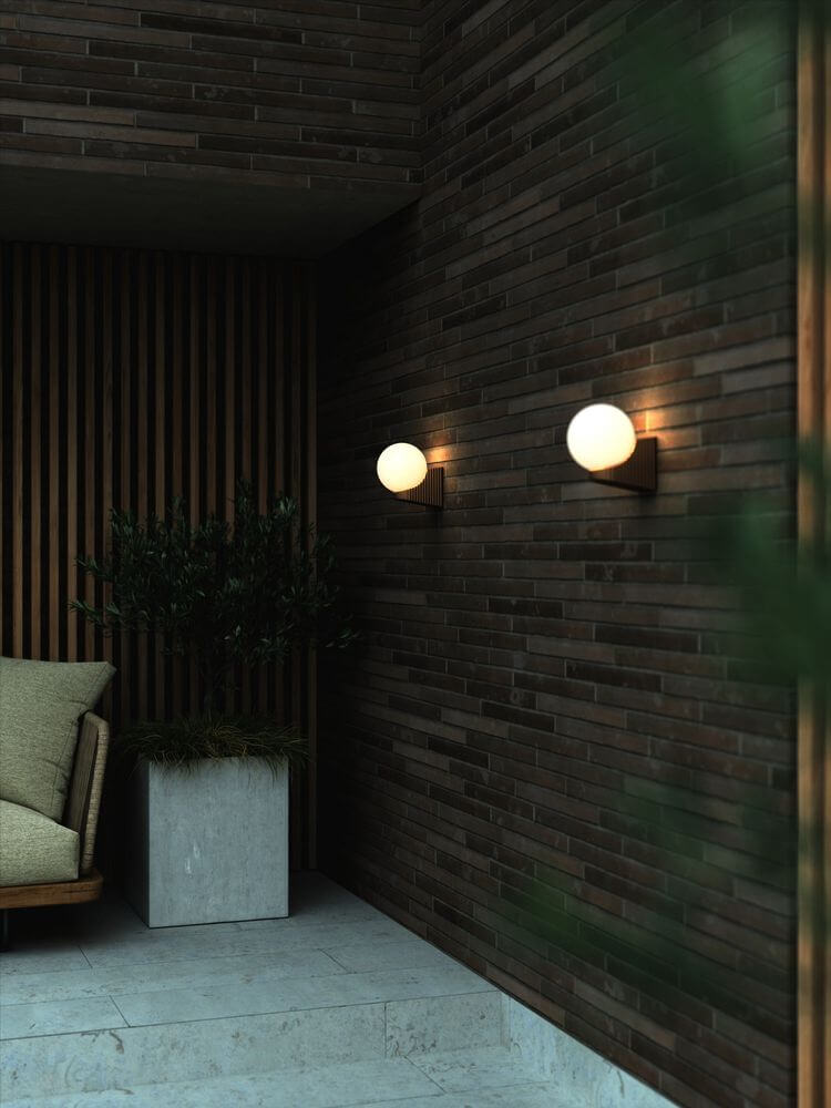 Außenwandlampe Hayley IP44 an einer Holz-Ziegelwand, mit dekorativer Beleuchtung und modernem Design.