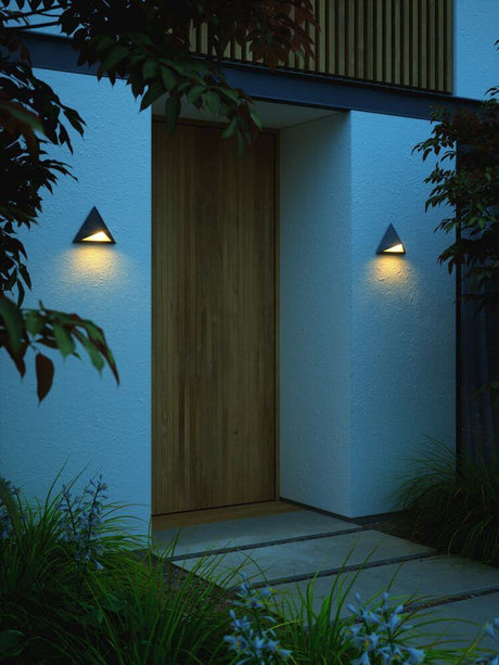 Außenwandlampe Konit IP44 an moderner Hausfassade, dreieckiges Design mit nach unten abstrahlendem Licht