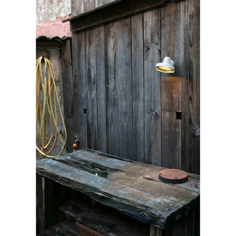 Außenwandleuchte BRONX IP44 Weiß an einer Holzwand über einer Holzarbeitstisch