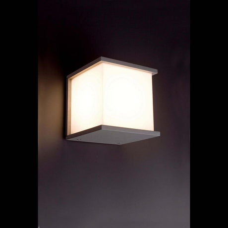 Außenwandleuchte KUBICK IP44 Grau an einer Wand montiert mit weichem Licht.