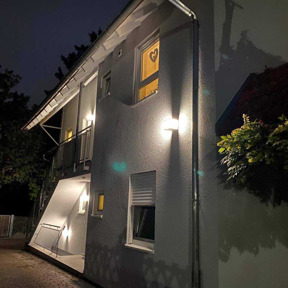 Außenwandleuchte KUBICK IP44 Grau an einem modernen Haus in der Nacht.