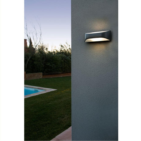 Outdoor wall light VIEW IP44 IP54 dark grey saltwater-resistant on a wall with garden and pool in the background.