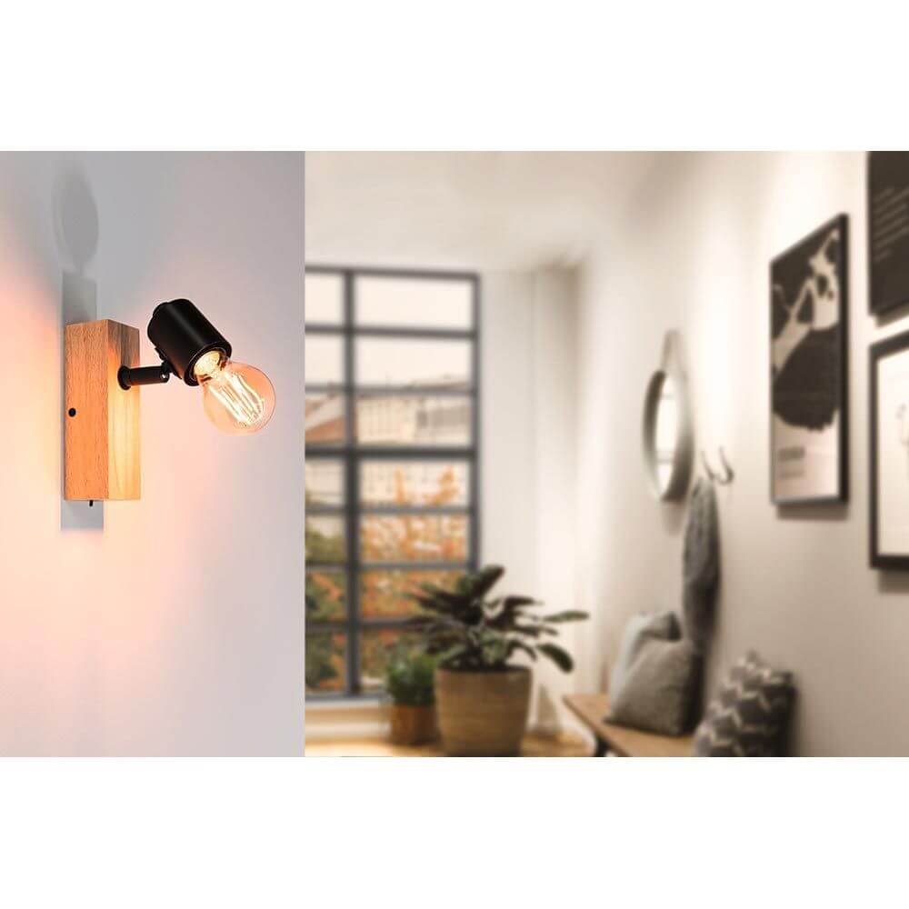 Balkenstrahler Spotlight Arvid Schwarz an einer Wand im modernen Raum mit Holz- und Schwarz-Elementen.