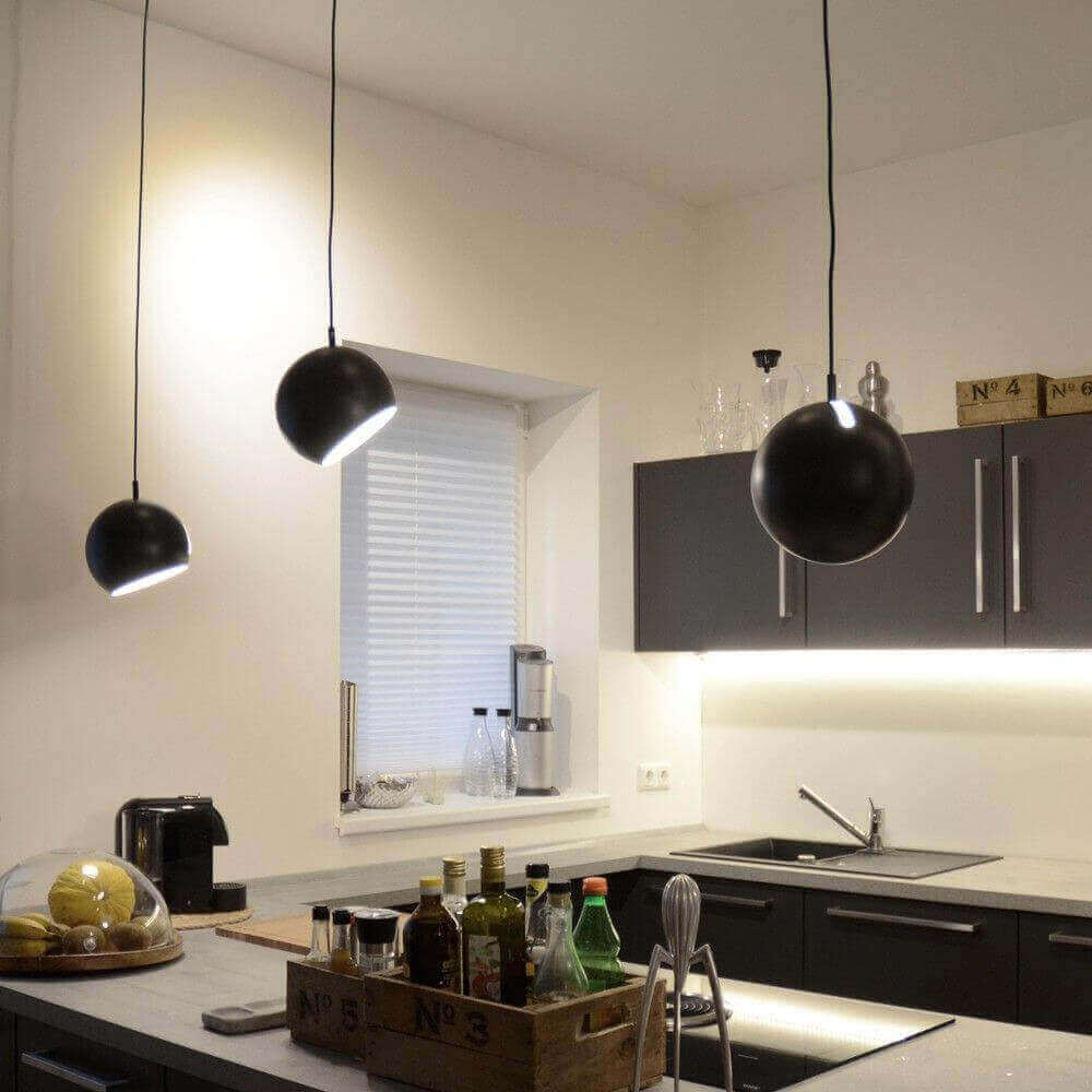 Moderne Küche mit stilvollen Pendelleuchten und eleganten Möbeln, ideal für ein zeitgemäßes Wohnambiente.