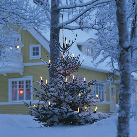 Baumkette Schaftkerzen teilbarer Stecker 16 klare Birnen IP44 an einem verschneiten Weihnachtsbaum.