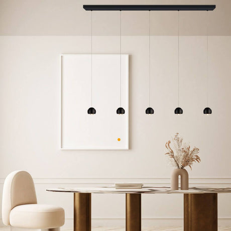 s.luce Beam LED Pendelleuchte mit fünf schwarzen Lampenschirmen über einem Esstisch in modernem Ambiente.