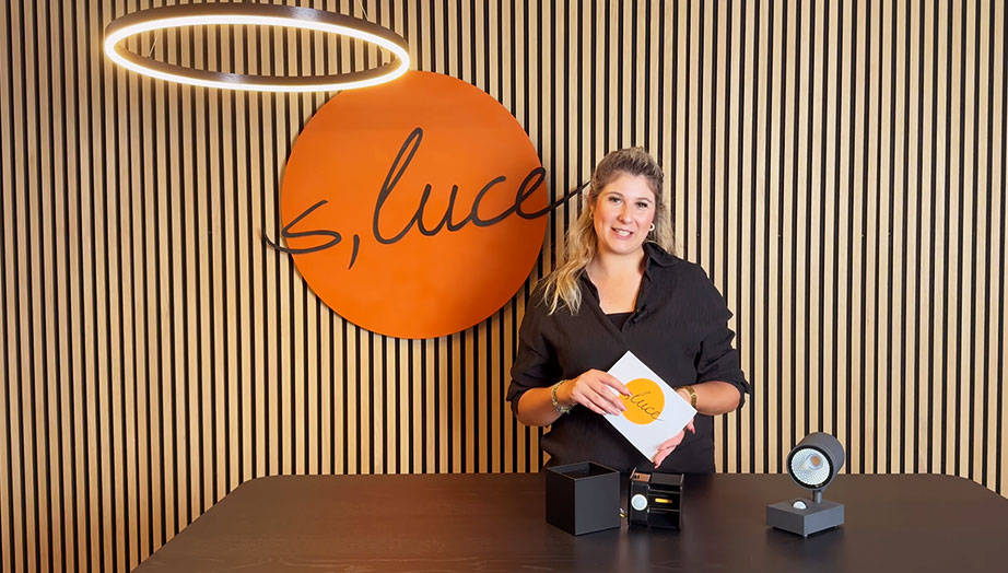 Eine Frau präsentiert Produkte vor einem modernen Holzhintergrund mit dem Logo von 'luce'.