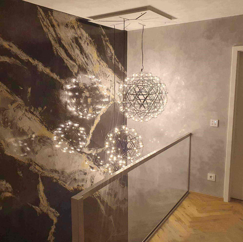 Hängelampen mit Lichtern in modernem Raumdesign, dekorative Wand mit marmoriertem Muster.