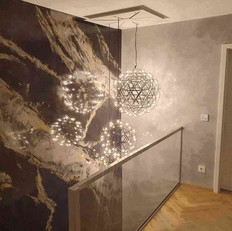 Hängelampen mit Lichtern in modernem Raumdesign, dekorative Wand mit marmoriertem Muster.