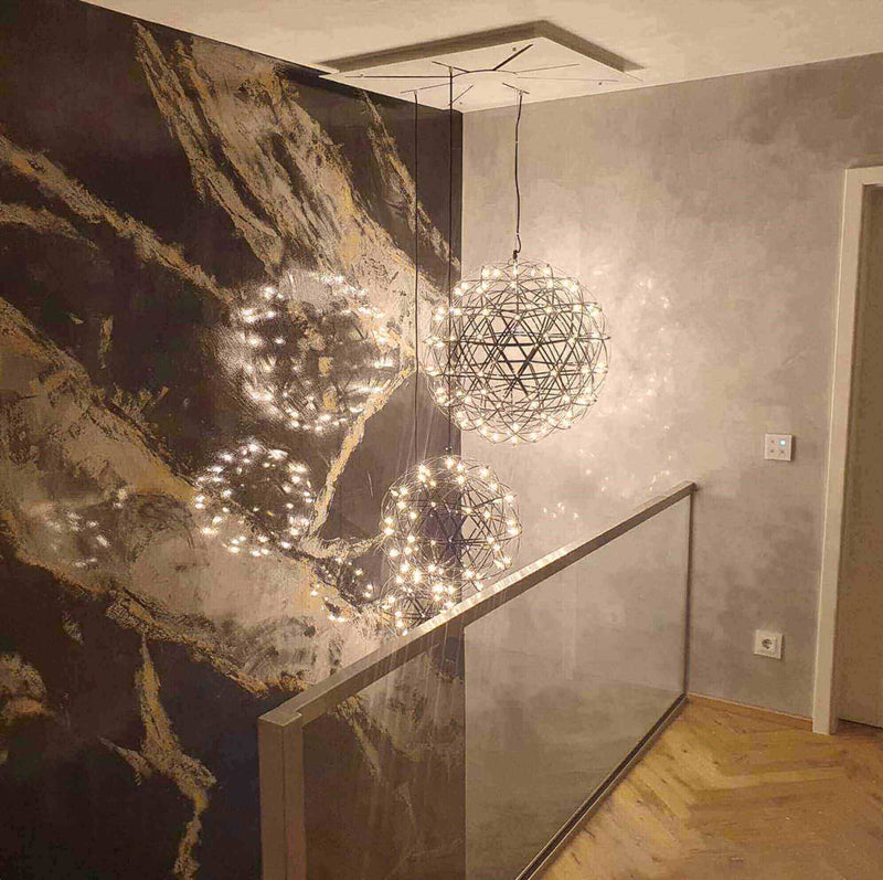 Hängelampen mit Lichtern in modernem Raumdesign, dekorative Wand mit marmoriertem Muster.