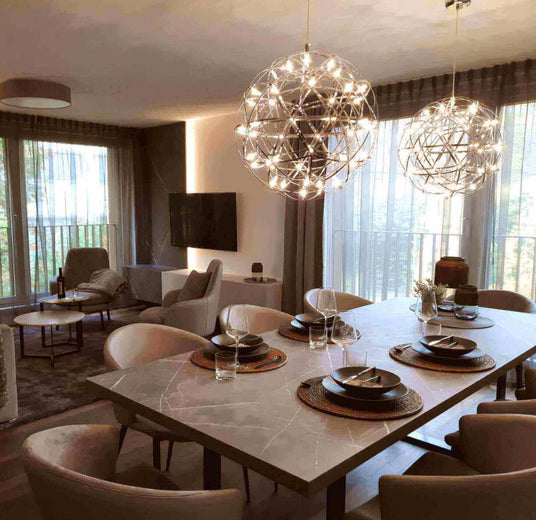 Modernes Esszimmer mit eleganten Lichtobjekten und stilvollem Tisch, ideal für gesellige Abende.