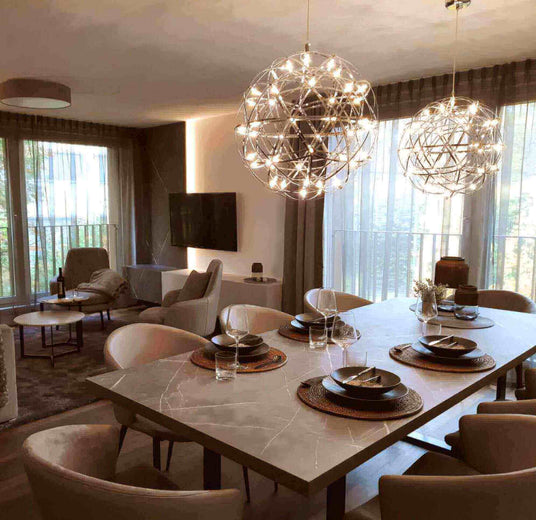Modernes Esszimmer mit eleganten Lichtobjekten und stilvollem Tisch, ideal für gesellige Abende.
