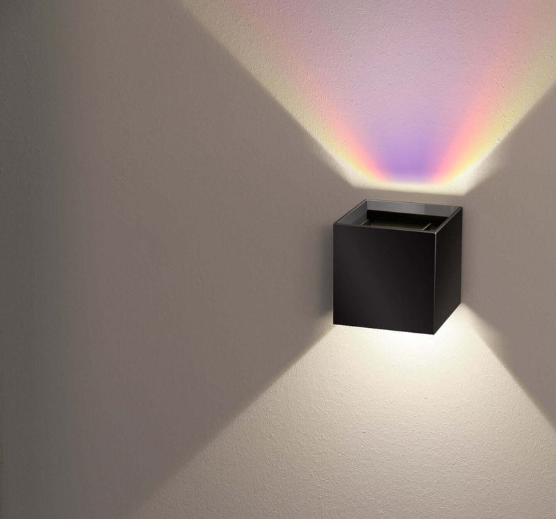 Moderne Wandleuchte in Schwarz mit farbigem Lichtschein, ideal für stilvolle Raumgestaltung.