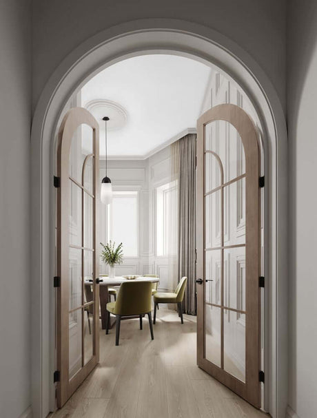 Vue à travers une entrée élégante en forme d’arche sur une salle à manger lumineuse avec un mobilier raffiné.