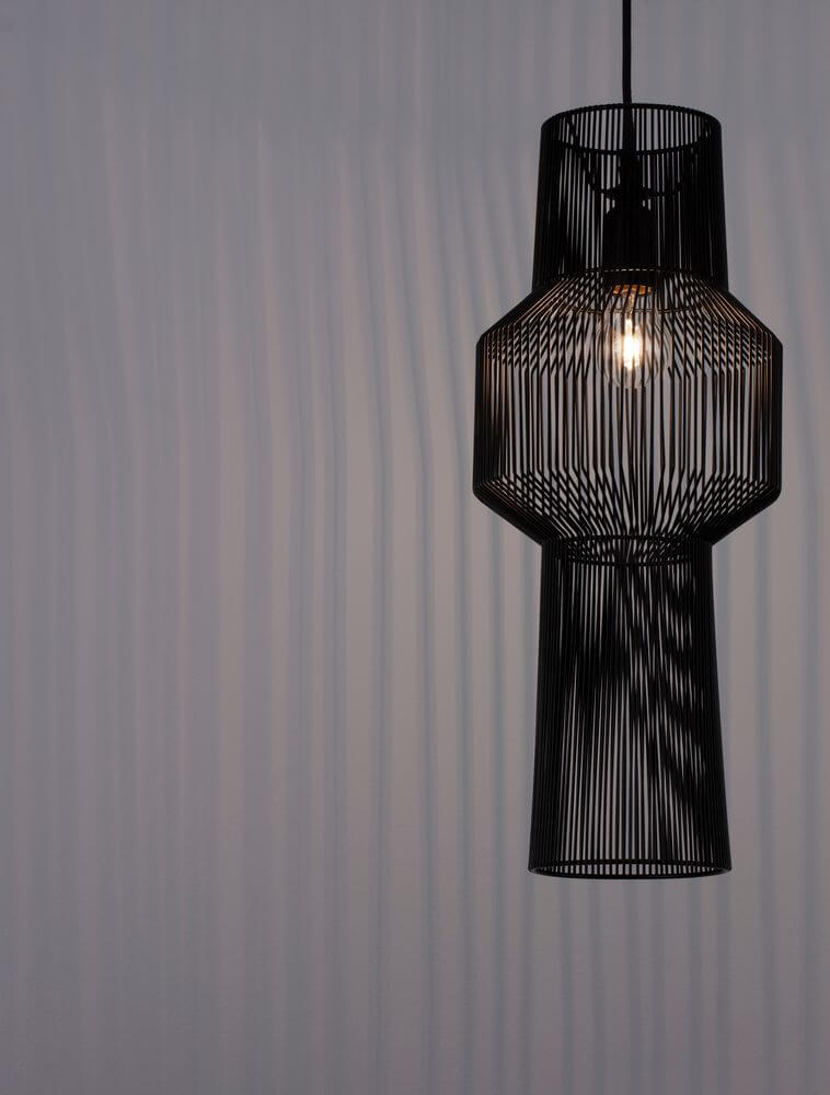 Bredo Pendelleuchte Ø 21cm Schwarz hängt elegant von der Decke und strahlt ein warmes Licht aus.