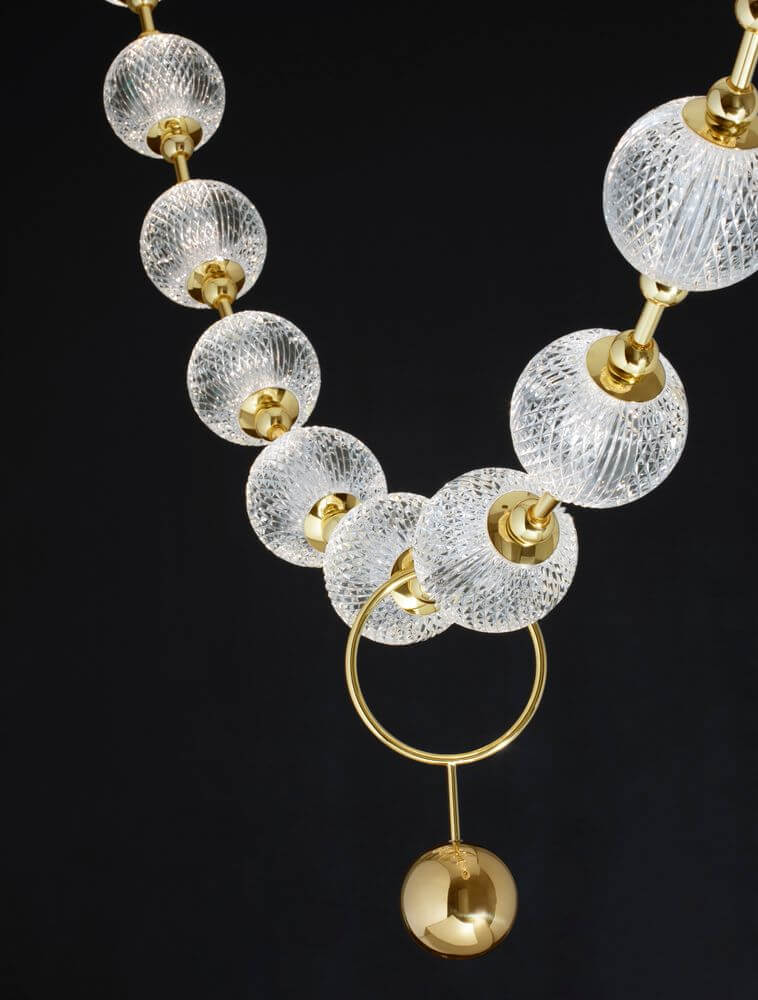 Brillante LED Pendelleuchte 12-flammig 3200K mit eleganten Glas- und Goldakzenten auf schwarzem Hintergrund.