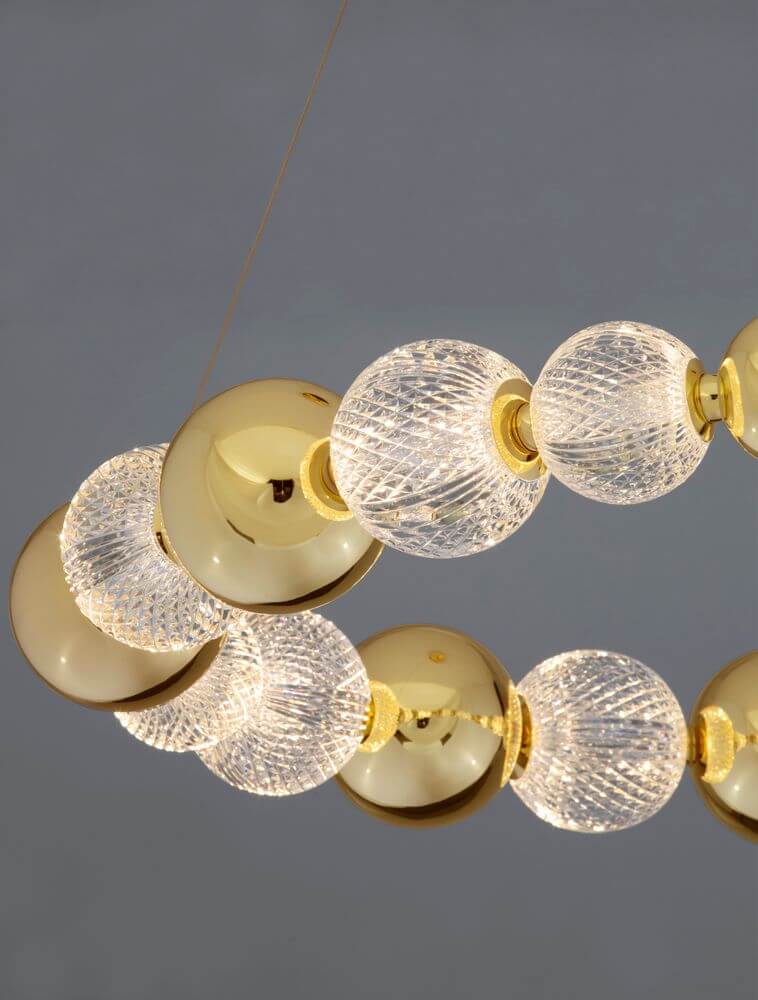 Brille LED Pendelleuchte 12-flammig Ø 94cm 3200K Gold mit glänzenden goldenen und lichtdurchlässigen Glaskugeln.