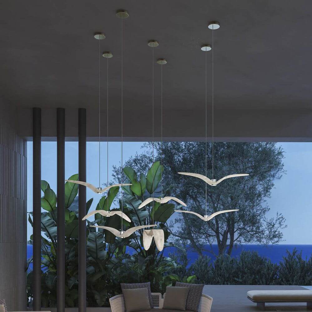 Brokis Hängeleuchte Night Birds waagrechte Flügel 78cm in modernem Wohnraum mit Pflanzen und Meerblick.